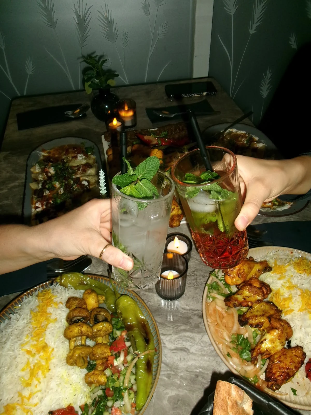 Zwei mit Minze garnierte Drinks beim Anstoßen im DENJ